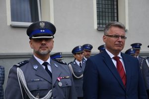 Zbliżenie na prezydenta miasta obok policjanta.