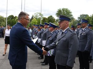 Policjanci ściskają dłoń prezydenta miasta.