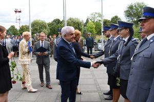 Policjanci ściskają dłonie cywili.