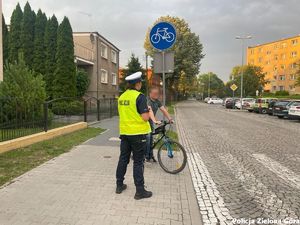 Policjantka zatrzymała rowerzystę przed przejściem dla pieszych.