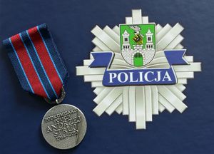 Medal na tle logo policyjnego.