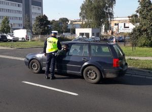 Policjant ruchu drogowego kontroluje trzeźwość kierowcy.