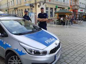 Policjanci stojący przy samochodzie.