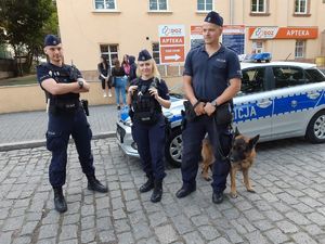 Policjanci na patrolu z psem policyjnym.