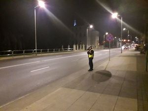 Policjantka bada prędkość nadjeżdżających samochodów.