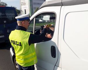 Policjant badający trzeźwość kierowcy samochodu.