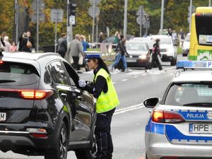 Policjantka sprawdza trzeźwość kierowcy samochodu osobowego.