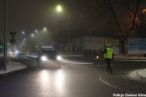 Policjant zatrzymujący samochód osobowy do kontroli.