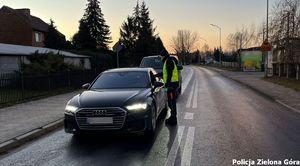 Policjant zatrzymał kierowce ciemnego samochodu osobowego.