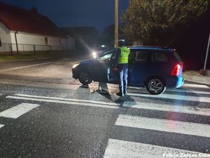 Policjant zatrzymujący samochód osobowy.