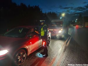 Policjant badający trzeźwość kierowcy samochodu osobowego.