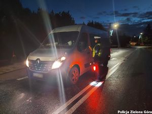 Policjant bada trzeźwość kierowcy busa.