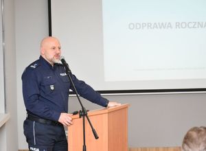 Policjant omawiający odprawę kadry kierowniczej.