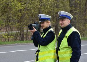 Dwójka policjantów mierząca prędkość nadjeżdżających samochodów.