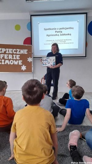 Policjantka omawia prezentacje na temat bezpieczeństwa w ferie.