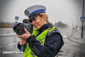 Policjantka mierząca prędkość nadjeżdżających samochodów.