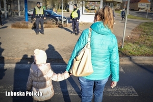 Mama z dzieckiem przechodząca przez pasy.