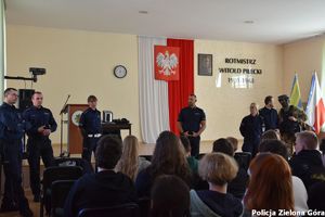 Grupa policjantów promuje zawód policjanta absolwentom szkoły średniej w Sulechowie.