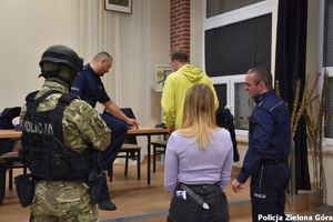 Grupa policjantów promuje zawód policjanta absolwentom szkoły średniej w Sulechowie.
