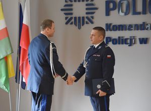 Nowy komendant podający dłoń drugiemu policjantowi.