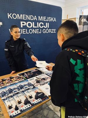 Policjantka daje chłopakowi ulotkę na stoisku Komendy Miejskiej Policji w Zielonej Górze