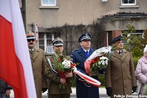 Komendant Miejski Policji podinspektor Tomasz Szuda z kwiatami przed pomnikiem Pamięci Ofiar pomordowanych w Katyniu w kwietniu 1940 roku