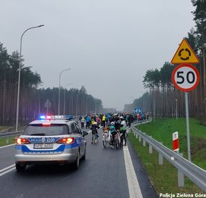 Policyjny radiowóz zabezpiecza tyły rajdu rowerowego