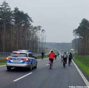 Policyjny radiowóz zabezpiecza tyły rajdu rowerowego