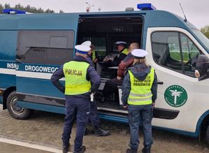 policjanci ruchu drogowego i funkcjonariusze Inspekcji Transportu Drogowego z zatrzymanym mężczyzną w busie inspekcji