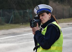 Policjantka mierząca prędkość samochodów.