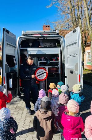 Policjant uczy dzieci na temat kontroli drogowej.