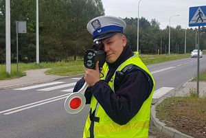 Policjant mierzący prędkość nadjeżdżających samochodów.