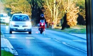 Moment z nagrania gdzie motocyklista wyprzedza samochód