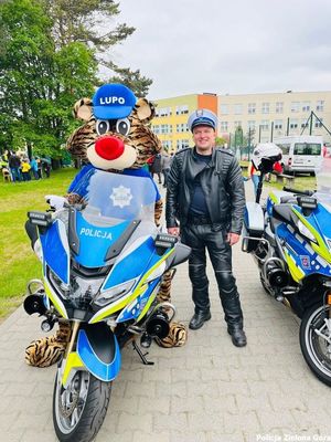 Maskotka policyjna LUPO na motocyklu policyjnym.