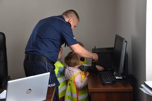 Komendant miejskiej policji w Zielonej Górze pokazuje dzieciom krótkofalówkę