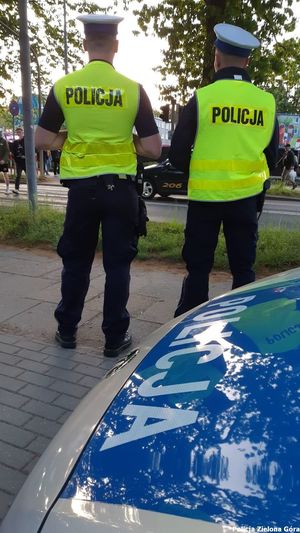 Dwójka policjantów z wydziału ruchu drogowego stojąca przed jezdnią.