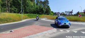 Wóz policyjny i motocykl na rondzie.