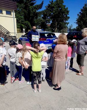 Policjant z dziećmi przy radiowozie