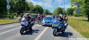 Policjanci Ruchu Drogowego na motocyklach i radiowóz policyjny na przodzie rajdu rowerowego