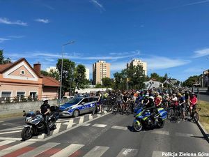 Policjanci na motocyklach i radiowóz policyjny na przodzie rajdu rowerowego