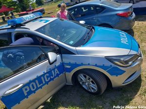 Policjant pokazuje radiowóz