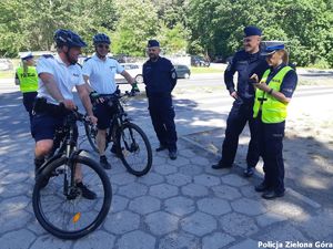 Policjanci z patrolu rowerowego rozmawiają z innymi policjantami