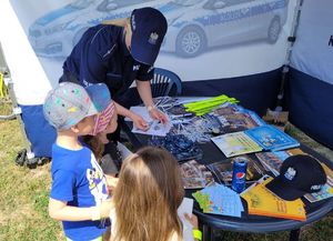 Policjantka rozdaje dzieciom upominki