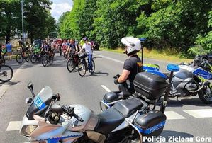 Policjant na motorze pilnuje porządku przy imprezie sportowej.