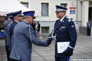 Funkcjonariusz ściskający dłoń drugiego policjanta.