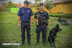 Funkcjonariusz policji trzymający trofeum.