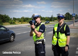 Dwójka policjantów kontrolująca prędkość samochodów.