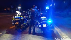 Policjant z dwoma motocyklami policyjnymi.