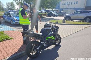 Policjant legitymuje kierowcę motocykla.