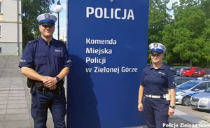 Policjantka i policjant ruchu drogowego stoją przy napisie Komenda Miejska Policji w Zielonej Górze